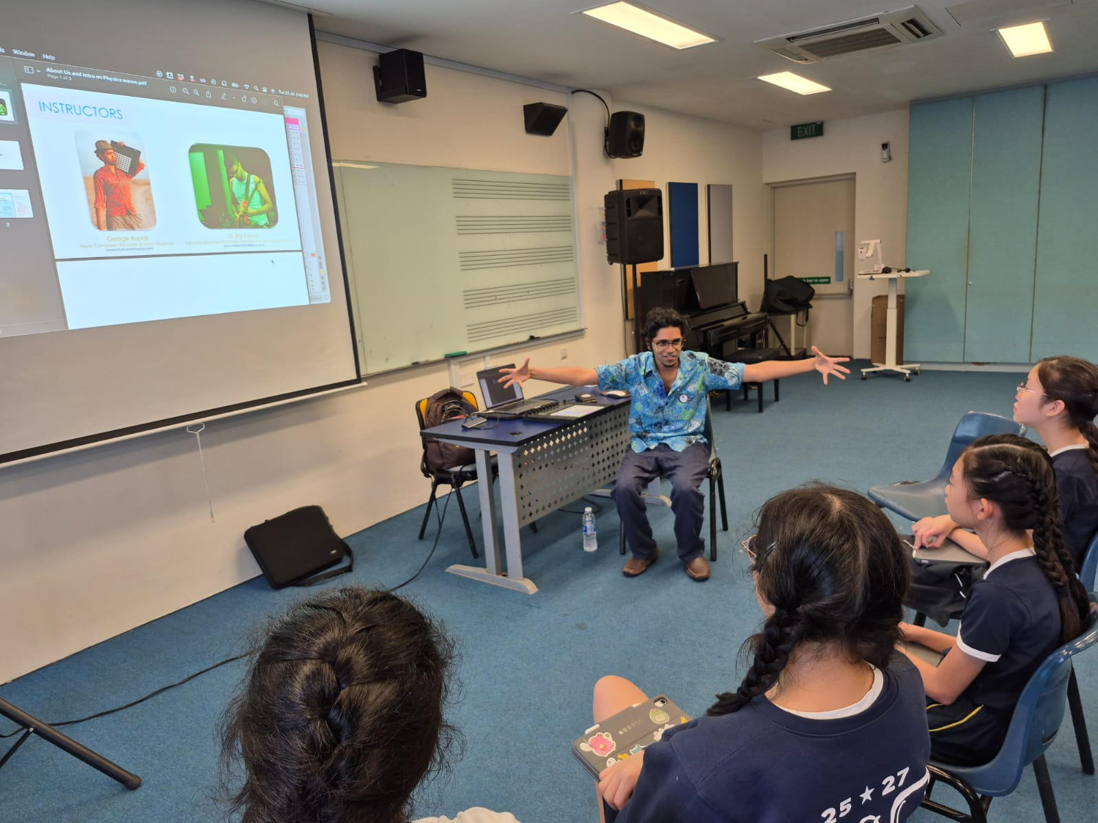 Group listening to music workshop facilitator Music Workshop Singapore group listening to a facilitator in a music‑based team‑building workshop in Singapore