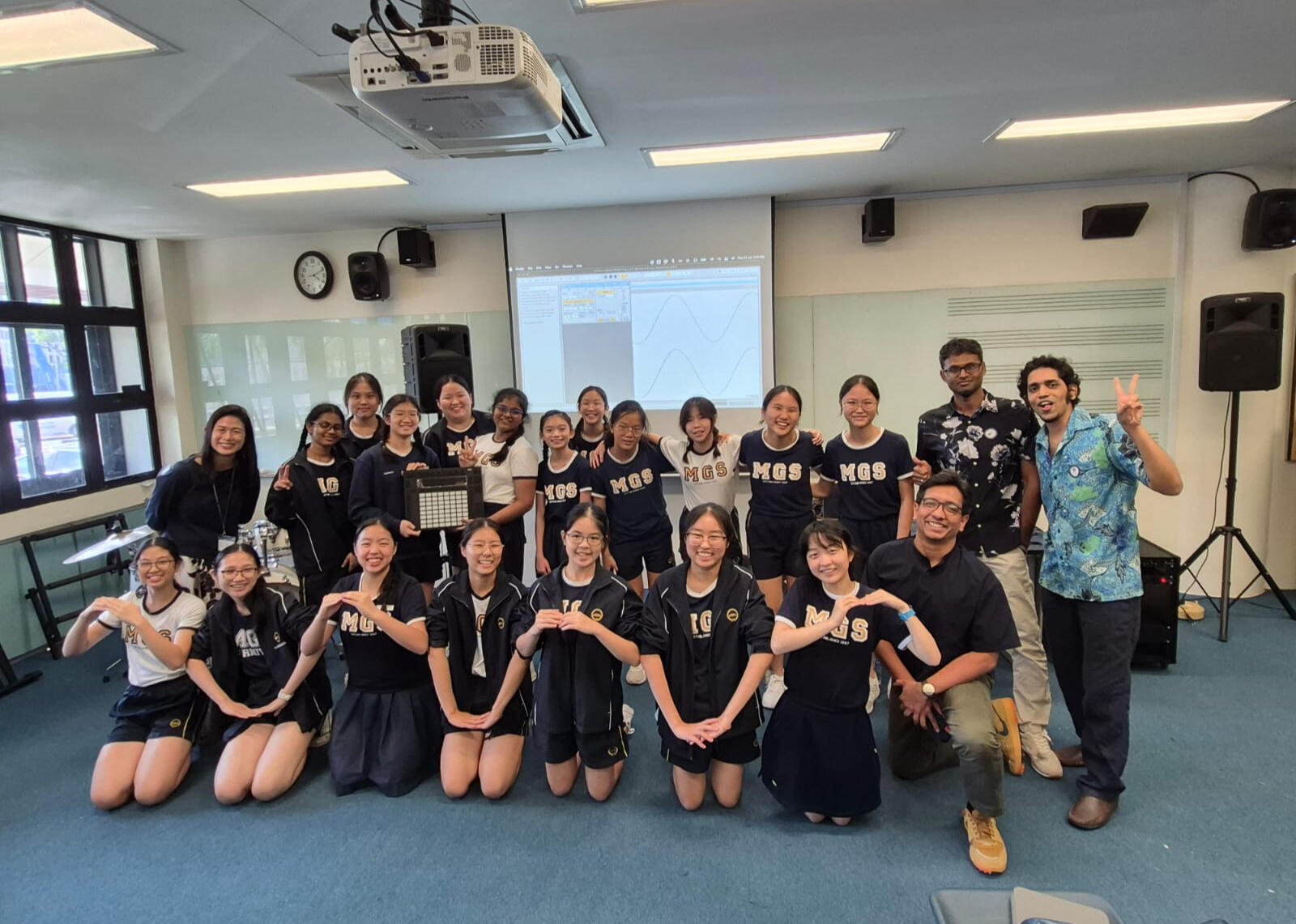 Group bonding through music in Singapore Music Workshop Singapore group posing together after finishing a song they wrote in a team‑building music workshop in Singapore